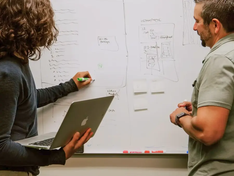 Engineers mapping a client's workflows on a whiteboard